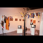 “The Stone Show” - Zachery Longboy installation three TV monitors on plinths clothes hanging prints on wall
